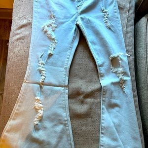 Vibrant brand distressed jeans. Light blue extreme flare leg. With Jean fringe